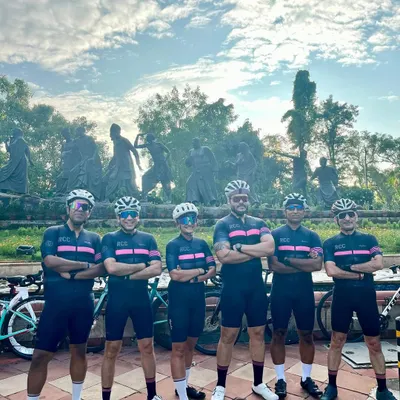 The team lines up in matching kits to celebrate a member's birthday ride. The Gyarah Murti statue provides a powerful backdrop for our group photo.