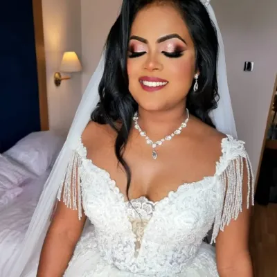 A beautiful Christian bride, looking like a princess in her white gown and tiara. The makeup is glamorous with a defined eye and a soft berry lip.