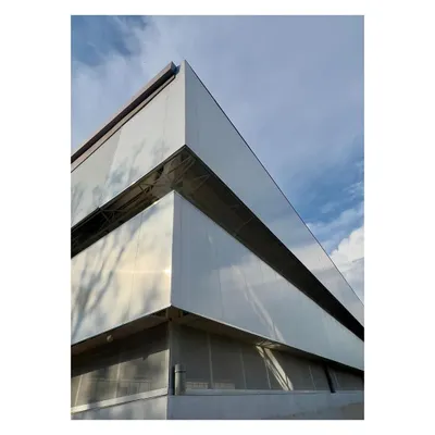 The exterior of an industrial project under construction, featuring polycarbonate and metal wall panels. The design focuses on creating a clean, efficient, and light-filled factory environment.