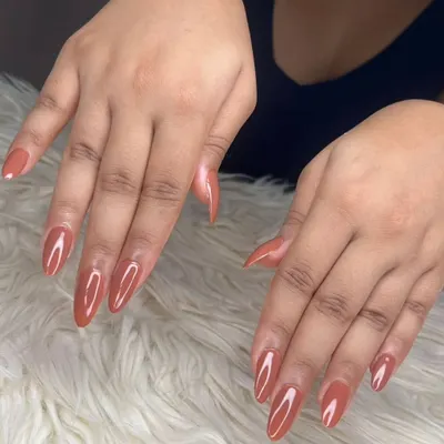 A full view of the glossy terracotta gel polish on long, almond-shaped extensions, showcasing their consistent shape and flawless application.