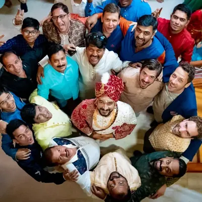 A fun, top-down shot of the groom surrounded by his groomsmen, all celebrating together.