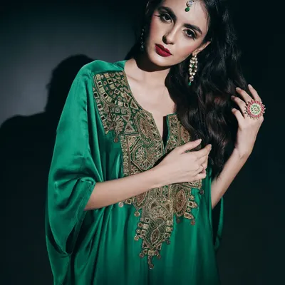 In this studio portrait, I used dramatic, low-key lighting to emphasize the luxurious feel of the emerald green kaftan. The focus is on the intricate gold embroidery and the model's commanding presence, creating a powerful image for a designer campaign.