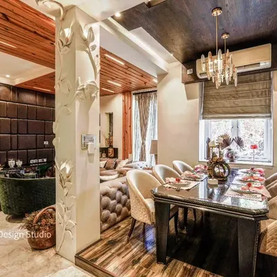 An open-plan living and dining area where a custom-carved pillar elegantly separates the two zones, showcasing a blend of rich textures and luxurious details.