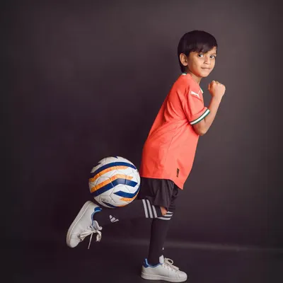 For the little sports star in your family. A simple, dark backdrop makes this young football player and his bright jersey stand out.