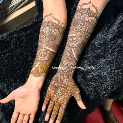 A complete bridal mehendi set showcasing a beautiful blend of floral and geometric patterns. The design extends up the arm, ensuring a stunning look from every angle.