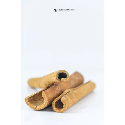 A minimalist, high-key photograph of cinnamon sticks. This clean and simple composition focuses on the natural texture and form of the spice, ideal for packaging or editorial content.