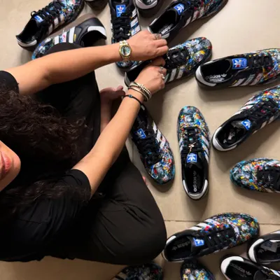 Surrounded by the finished product of a bulk order for a private client. This project involved hand-painting nine pairs of Adidas Sambas, each with a unique but cohesive splatter art design.