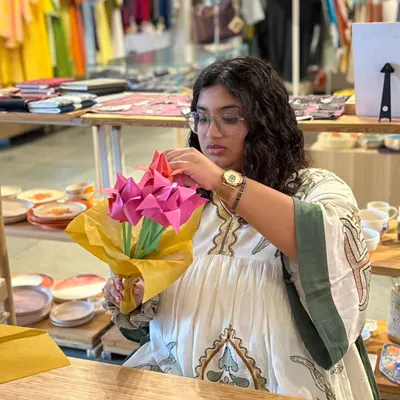 A participant at our origami workshop carefully assembles a bouquet of paper flowers. These sessions are designed to be mindful and relaxing, allowing you to create something beautiful with your own hands.