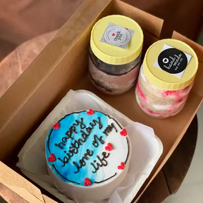 A romantic gift set featuring a bento cake with the message "happy birthday love of my life" and two cake jars. The blue and white ombre effect on the cake adds a beautiful touch.