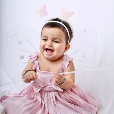 A burst of pure happiness. This little girl in a pink fairy dress laughs with delight, creating an infectious and joyful portrait.