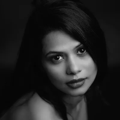 An intense and direct black and white headshot. I used a single light source to create this high-contrast, chiaroscuro effect, drawing all attention to the subject's powerful gaze.