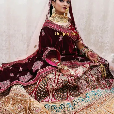 A classic bridal masterpiece. This velvet maroon and multi-panel lehenga with heavy zardozi and stone work is designed for the bride who wants a truly royal and traditional wedding day look.