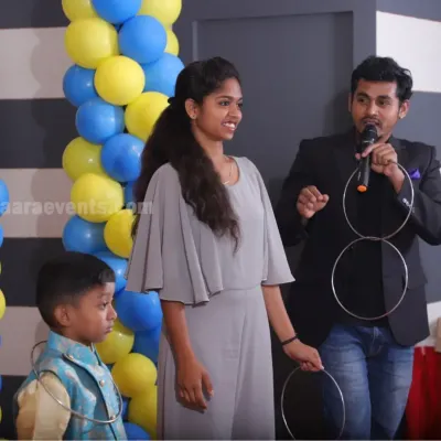 I am demonstrating the impossible with the linking rings, a staple of classic stage magic. This act is great for engaging both kids and adults at any celebration.
