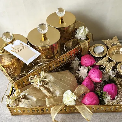 A truly grand gesture for Diwali, this hamper features golden trays laden with crystal-topped jars, festive potlis, and decorative flowers. It’s a luxurious gift designed to impress and delight your most cherished connections.