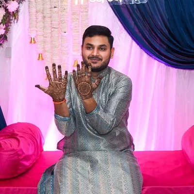 The groom playfully shows off his hands adorned with mehendi. We capture the fun and excitement of the groom's mehendi ceremony just as much as the bride's.
