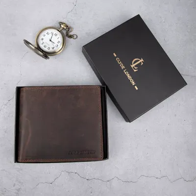 A dark brown distressed leather wallet from Clyde London, shown in its elegant black gift box with a classic pocket watch.
