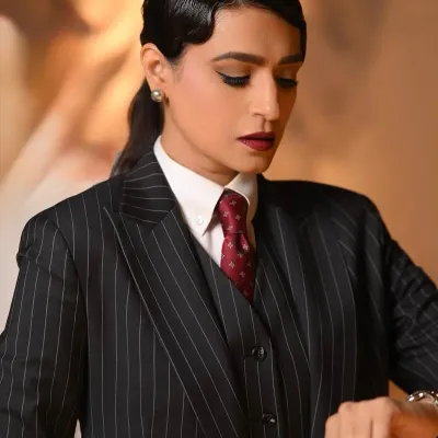 A powerful editorial look. The focus is on creating an "old money" aesthetic with a sharp, androgynous suit, sculpted finger waves, and a bold, matte lip.