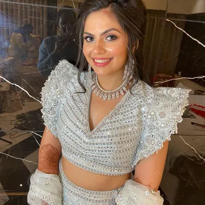 A close-up of a happy client in our powder blue and silver lehenga. The intricate mirror work on the blouse is a detail we absolutely love.