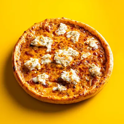 A classic menu shot for Hundo Pizza. The bright yellow background makes the cheese and toppings on this pizza look extra appetizing and ensures it stands out on a delivery app.