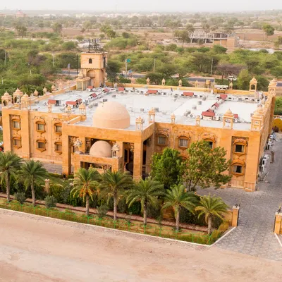 An aerial drone shot of the magnificent Chokhi Dhani Palace Hotel in Jaisalmer, showcasing the grand scale of a desert destination wedding.
