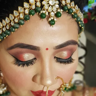 A detailed close-up of a bridal cut crease. I used warm red and shimmering gold eyeshadows with a sharp wing to create a dramatic and defined look that perfectly complements a traditional Indian bridal outfit.