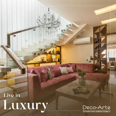 Experience the perfect blend of modern elegance and timeless charm. This living room under a floating staircase uses a plush velvet sofa and a grand chandelier to create a space that is both luxurious and inviting.