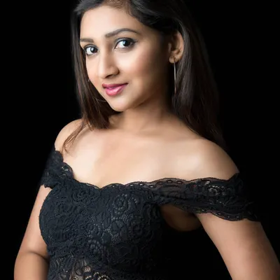 A simple yet effective portrait using low-key lighting. The focus is entirely on the model's face and expression, with the off-shoulder lace top adding a touch of style. This is a great example of a clean, modern headshot.