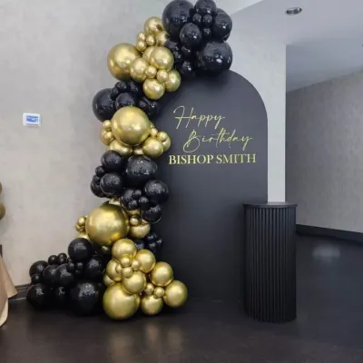 This is a clean and professional birthday decoration I did for a corporate executive. The setup includes a custom arched backdrop with personalized text and an elegant balloon garland in matte black and chrome gold.
