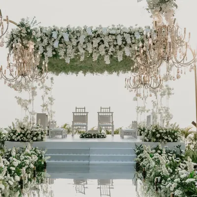 An all-white mandap against the Goa sea is pure magic. For this ceremony at the Grand Hyatt, we used a mirrored aisle, floating floral structures, and elegant chandeliers to create a space that felt like walking on clouds.