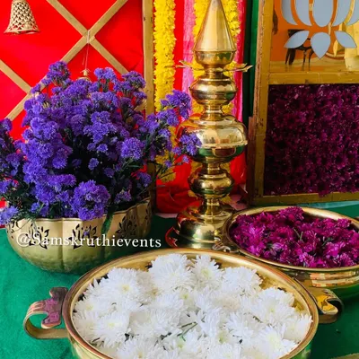 This setup features classic brass lamps and bowls filled with fresh white and purple flowers, adding an elegant touch to the decor.