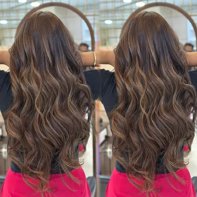 A perfect example of our hot mocha brown French balayage. Notice how the highlights are seamlessly blended to create a rich, dimensional effect with beautiful, wavy styling.