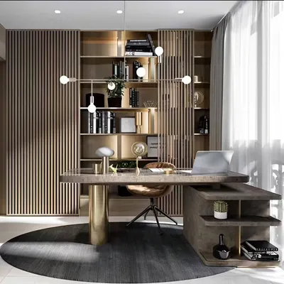 We designed this luxurious home office with a focus on sophistication and function. The space features a statement desk, extensive built-in bookshelves with a slatted wood screen, and a modern chandelier, creating an executive-level workspace at home.
