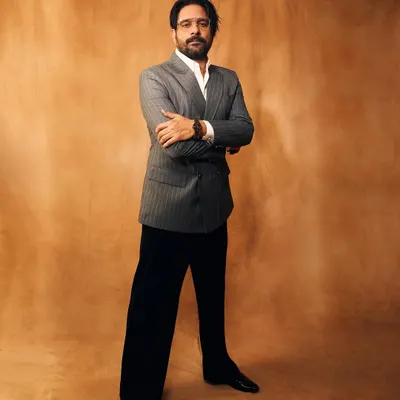 A full-length shot of Jaideep Ahlawat looking sharp in his award-winning suit. The double-breasted cut and wide-leg trousers are a modern take on classic tailoring.