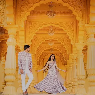 A fairytale moment in a grand, palace-like setting. The stunning yellow architecture and her twirling lehenga create a scene of pure elegance and romance at Sets in the City.