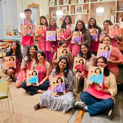 A large, happy group from a wine and paint workshop. These public sessions at cafes are a great way to meet new people and spend an afternoon creating together.