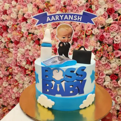 A classic Boss Baby cake perfect for a first birthday. This design features a personalized banner and fondant details like a milk bottle and briefcase, capturing the fun theme for your little one.
