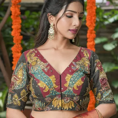 This V-neck blouse showcases a detailed Kalamkari fish motif, a symbol of prosperity and abundance. The artwork is highlighted with subtle sequin embellishments, adding a touch of sparkle to the traditional design.