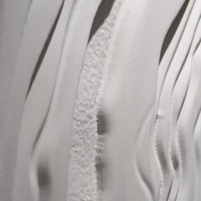 A detailed view of a sculptural wall panel, showing the interplay of smooth and rough textures. I designed this to capture the feeling of natural, flowing movement in solid stone.