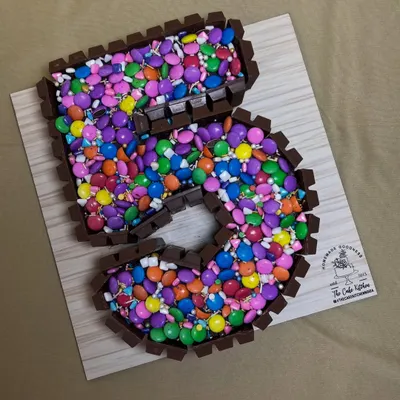 This number "5" cake is a chocolate lover's dream. It's framed with KitKat bars and filled to the brim with colorful Cadbury Gems.
