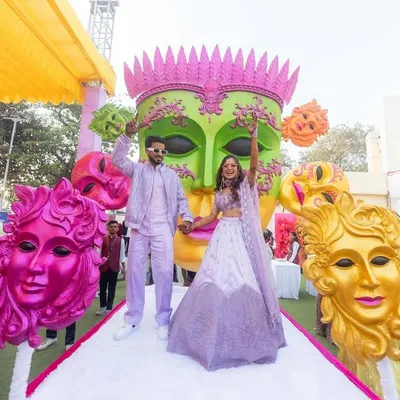 When love takes center stage, the world becomes a carnival. This couple's entry was a burst of joy, with colorful masks and entertainers creating a festive, playful atmosphere.