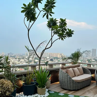 We designed this luxurious rooftop terrace to be a true urban sanctuary. It features a combination of wooden decking, artificial grass, curated planters, and comfortable wicker furniture, all overlooking the city skyline.