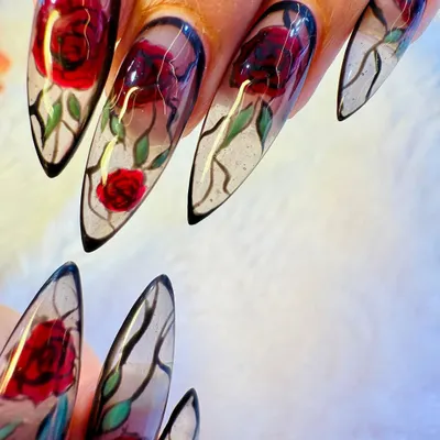 A true work of art. Our artist hand-painted these detailed red roses on long, stiletto-shaped extensions with a translucent, glass-like finish for a stunning 'enchanted rose' effect.