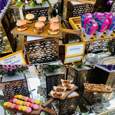 A vibrant assortment of party favorites. This collage displays chicken mini burgers, colorful macarons, popcorn cones, and other tasty bites, perfect for a fun and festive birthday celebration.