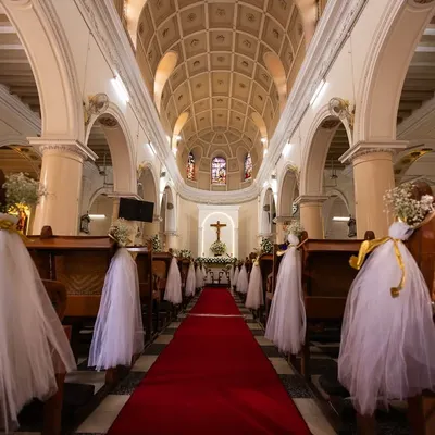 The aisle is ready. A wide shot of the beautifully decorated church, capturing the serene and grand atmosphere before the ceremony begins.