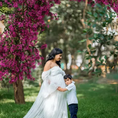 A precious moment between a mother and her son, who is lovingly hugging his new sibling through the baby bump. This is what family love looks like.