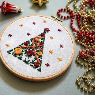 A beautiful hand-embroidered Christmas tree design. This piece uses classic embroidery stitches to create a delicate and festive piece of hoop art.