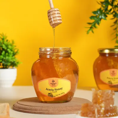 An action shot of honey being drizzled from a dipper. Capturing motion like this adds a dynamic and delicious element to product photography, perfect for showing the product's texture.
