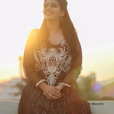 A beautiful rooftop portrait taken during the golden hour. The setting sun creates a stunning flare and a warm, magical light.