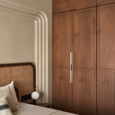 In the 'salt of earth bedchamber', I used a series of wall arches to conceal structural columns and create a beautiful feature. The design, with its rattan bed and lime-washed walls, is calm and inviting.