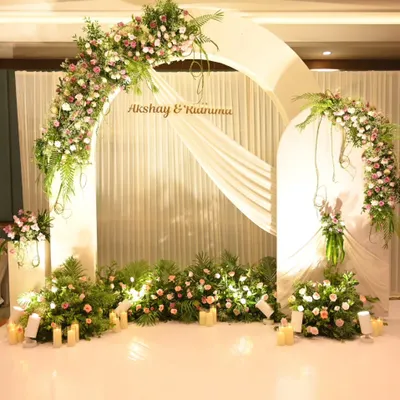 A dreamy floral arch in pastel pinks and whites creates the perfect backdrop for a Roka ceremony. The soft draping and warm candlelight add to the romantic ambiance.